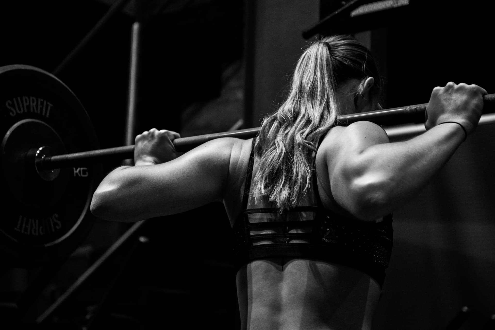 black and white photo of a woman lifting weights